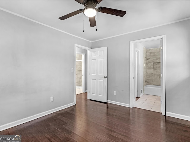 unfurnished bedroom featuring dark wood-type flooring, ceiling fan, ornamental molding, and connected bathroom