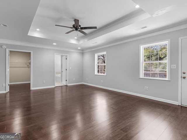 empty room with ceiling fan, ornamental molding, dark hardwood / wood-style flooring, and a raised ceiling