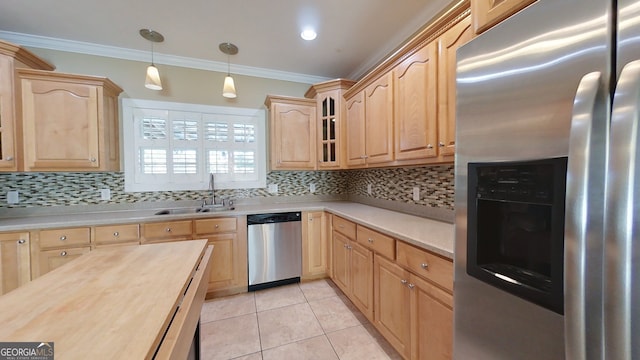 kitchen with appliances with stainless steel finishes, tasteful backsplash, sink, hanging light fixtures, and crown molding