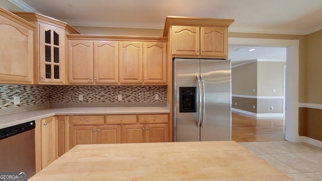 kitchen with appliances with stainless steel finishes, light brown cabinetry, and decorative backsplash