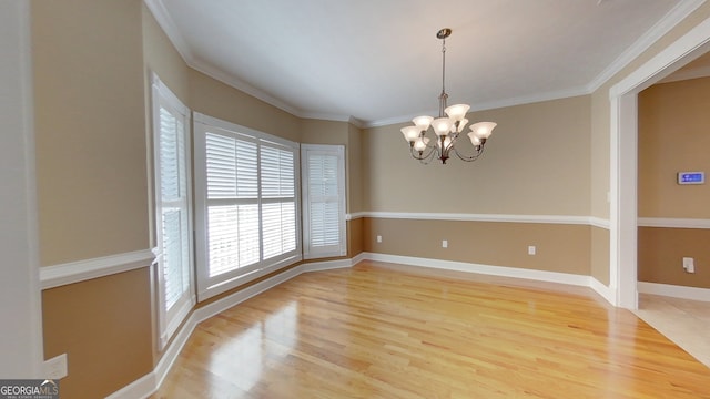 unfurnished dining area with crown molding, a notable chandelier, and light hardwood / wood-style floors