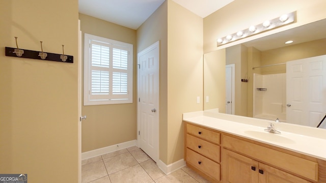 bathroom featuring tile patterned flooring, vanity, and walk in shower