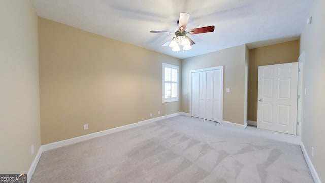 unfurnished bedroom with light colored carpet, a closet, and ceiling fan