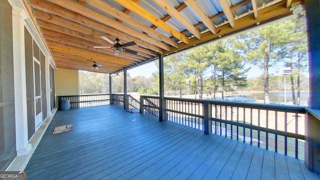 wooden deck with a water view and ceiling fan