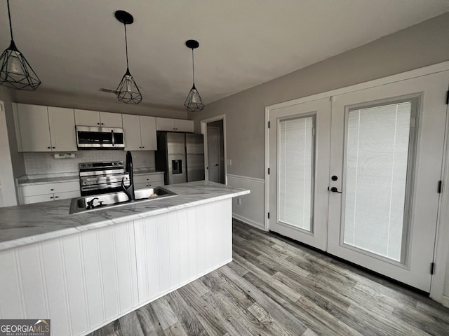 kitchen featuring pendant lighting, sink, white cabinetry, stainless steel appliances, and french doors