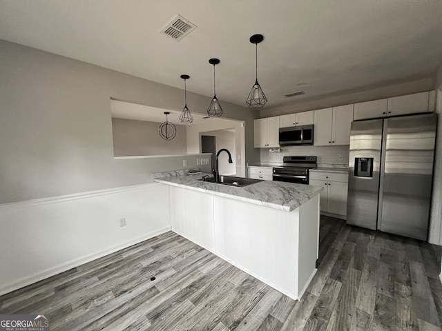 305 Clairemore Cir, Hinesville, GA 31313 - kitchen featuring dark wood-style flooring, a sink, stainless steel appliances, a peninsula, and visible vents