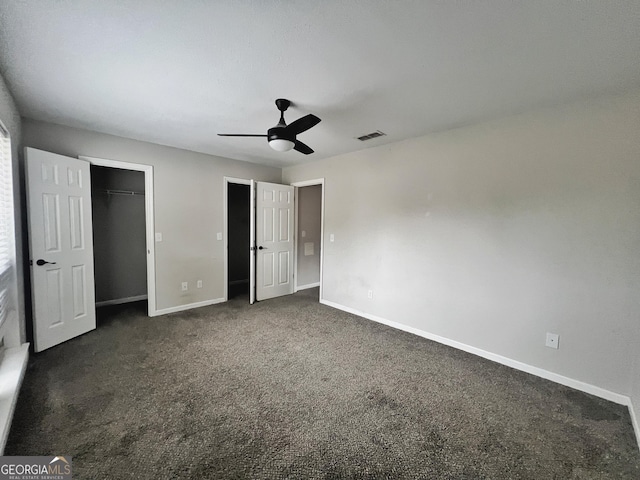 unfurnished bedroom featuring a closet, ceiling fan, and dark colored carpet