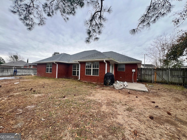 rear view of house with a patio area and a lawn