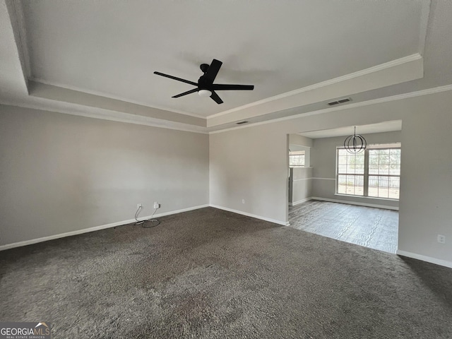 empty room with ceiling fan, ornamental molding, a raised ceiling, and carpet floors