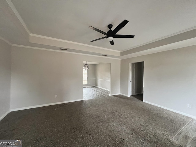 carpeted spare room with ceiling fan, ornamental molding, and a tray ceiling