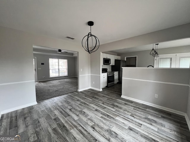 interior space with ceiling fan with notable chandelier and dark hardwood / wood-style floors