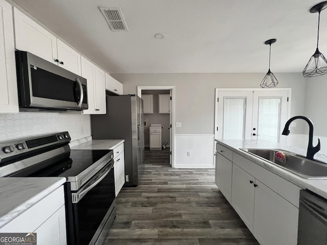 305 Clairemore Cir, Hinesville, GA 31313 - kitchen with white cabinets, appliances with stainless steel finishes, a sink, dark wood finished floors, and visible vents