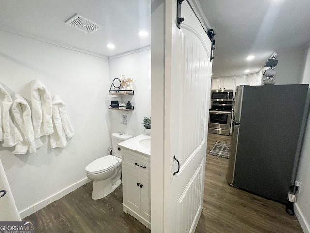 bathroom with vanity, hardwood / wood-style flooring, and toilet