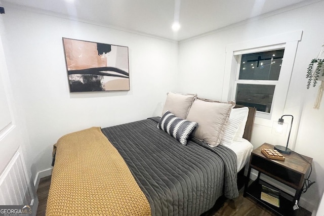 bedroom featuring dark hardwood / wood-style flooring and ornamental molding