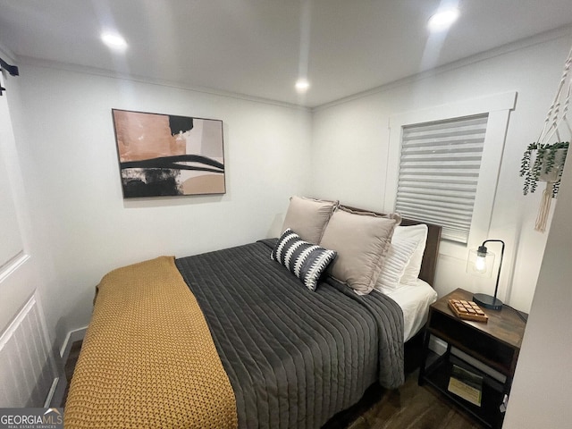 bedroom featuring crown molding and dark hardwood / wood-style flooring