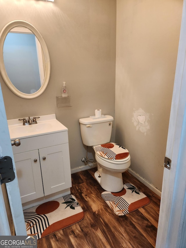 bathroom featuring vanity, hardwood / wood-style floors, and toilet