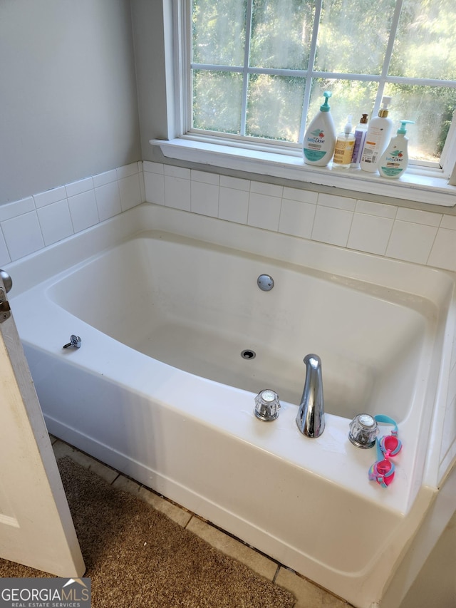 bathroom with tile patterned flooring and a bathtub