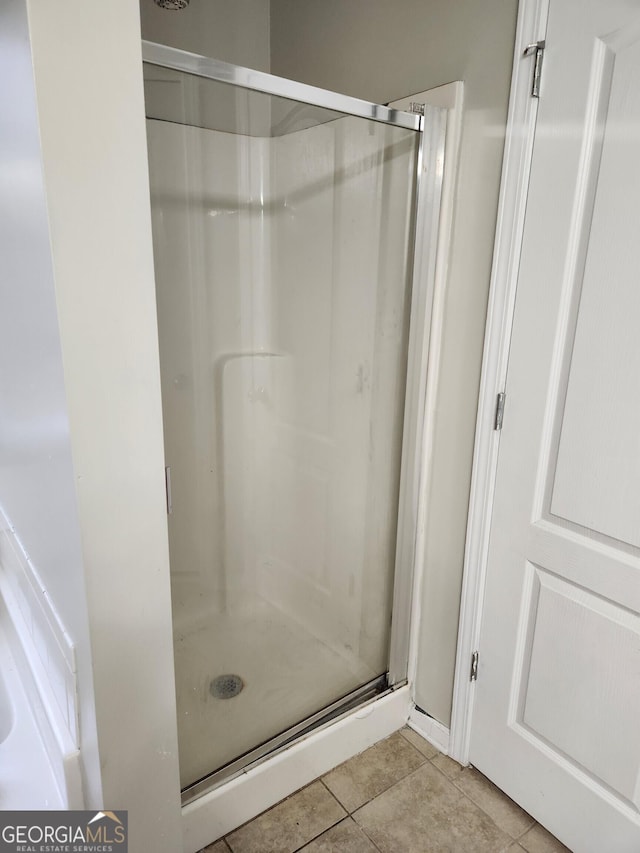 bathroom featuring tile patterned floors and a shower with door