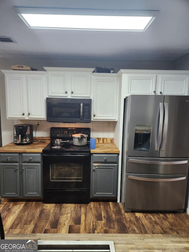 kitchen featuring white cabinetry, decorative backsplash, dark hardwood / wood-style flooring, and black appliances