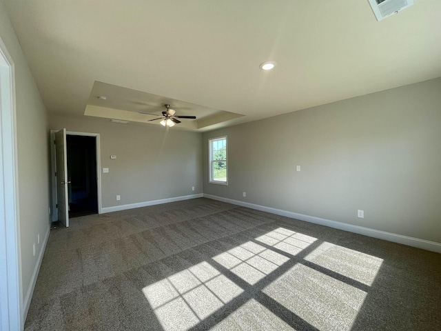 unfurnished room featuring ceiling fan, a raised ceiling, and carpet