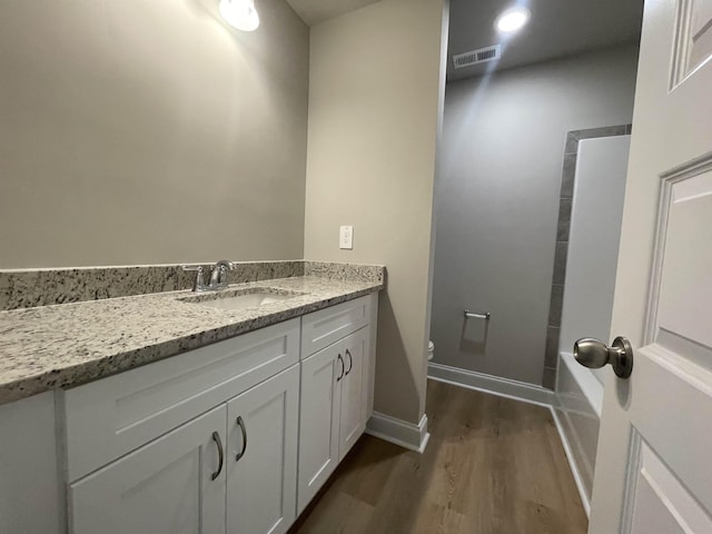 bathroom featuring vanity, wood-type flooring, and toilet