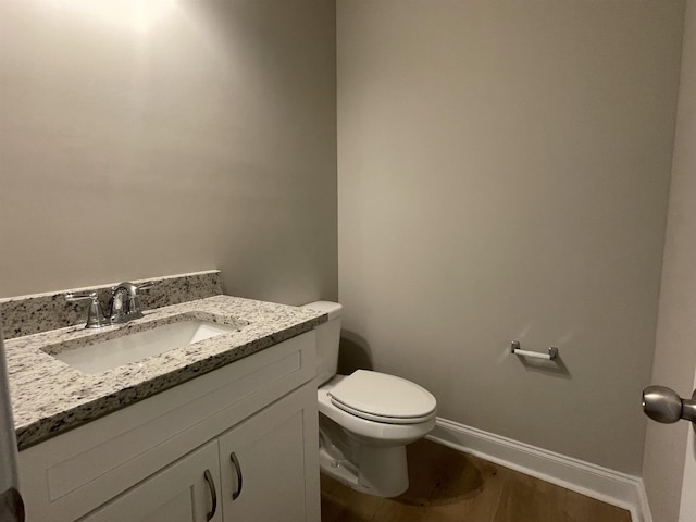 bathroom with vanity, toilet, and wood-type flooring