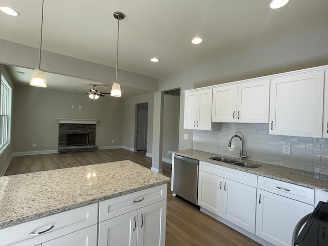 kitchen featuring sink, white cabinets, hanging light fixtures, stainless steel dishwasher, and ceiling fan