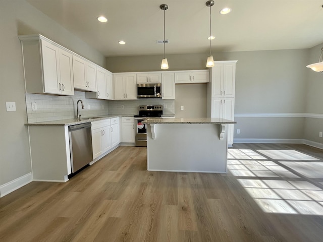 kitchen featuring a kitchen island, white cabinetry, and appliances with stainless steel finishes