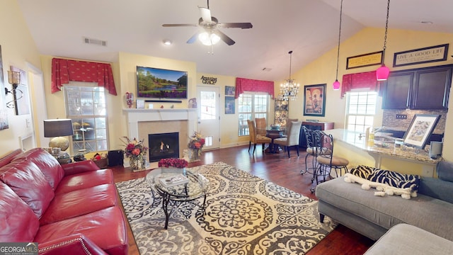 living room featuring lofted ceiling, ceiling fan with notable chandelier, and dark hardwood / wood-style flooring