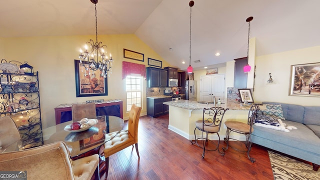 kitchen featuring lofted ceiling, a breakfast bar area, tasteful backsplash, appliances with stainless steel finishes, and kitchen peninsula