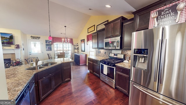 kitchen with lofted ceiling, sink, tasteful backsplash, hanging light fixtures, and stainless steel appliances