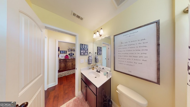 bathroom featuring hardwood / wood-style flooring, vanity, and toilet