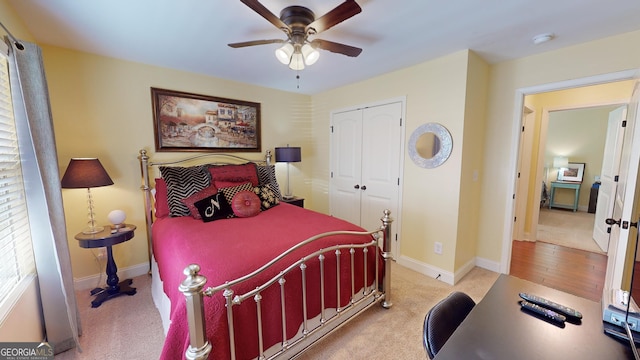 carpeted bedroom with ceiling fan and a closet