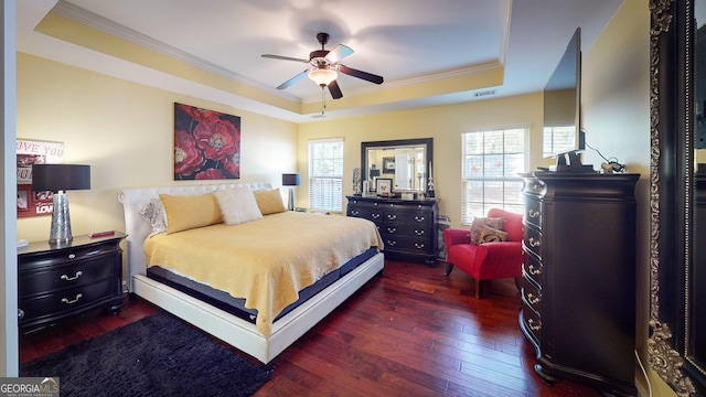 bedroom with a raised ceiling, ornamental molding, dark hardwood / wood-style floors, and ceiling fan