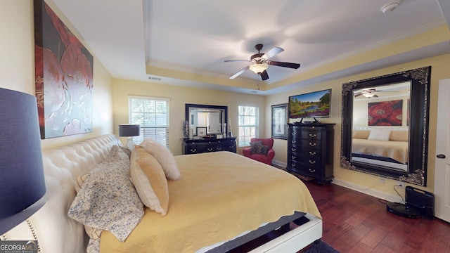 bedroom with ceiling fan, ornamental molding, a tray ceiling, and dark hardwood / wood-style flooring