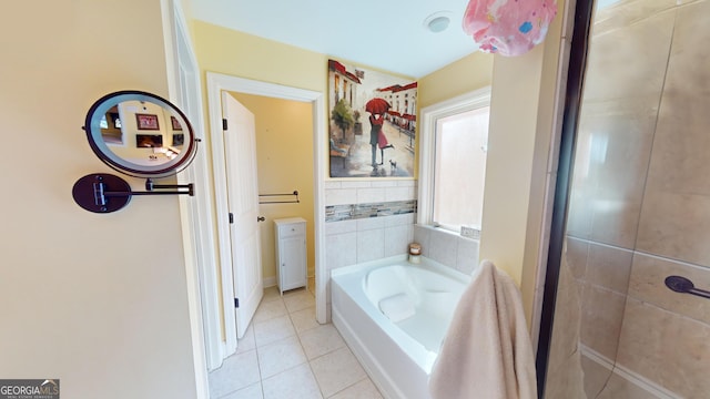 bathroom with a tub to relax in and tile patterned flooring