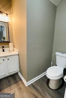 bathroom with hardwood / wood-style flooring, vanity, and toilet