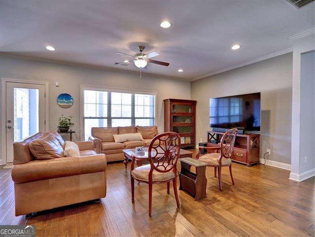 living room with hardwood / wood-style flooring, ceiling fan, ornamental molding, and a wealth of natural light