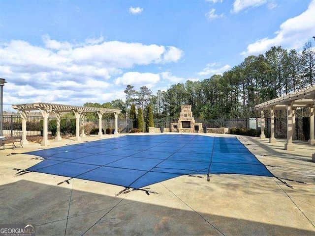 view of swimming pool featuring a pergola, a patio, and an outdoor stone fireplace