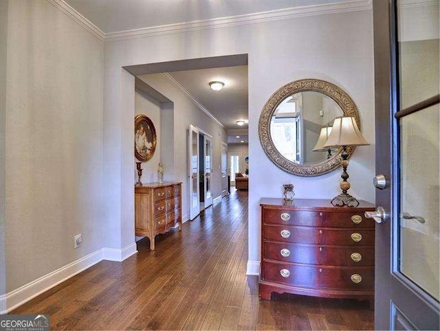 corridor with dark wood-type flooring and ornamental molding