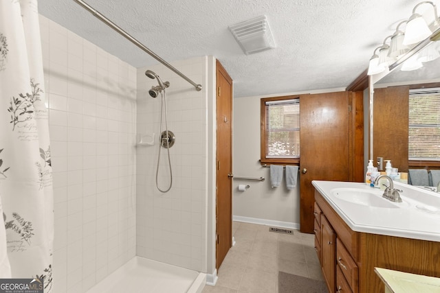 bathroom featuring vanity, a textured ceiling, and a shower with curtain