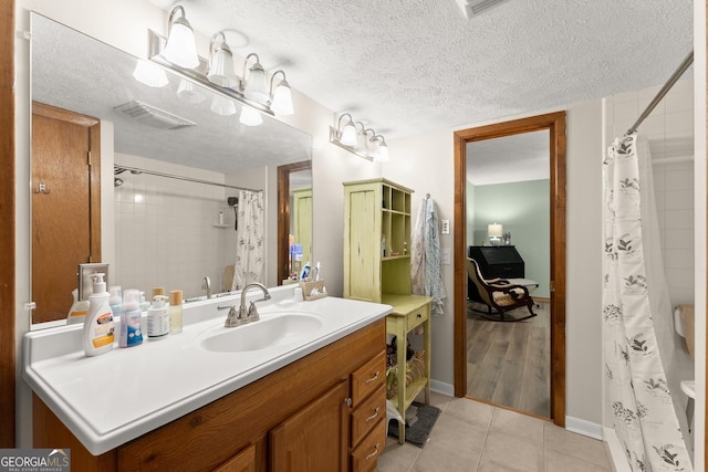 bathroom featuring vanity, a textured ceiling, and tile patterned floors