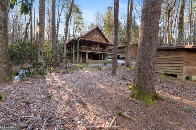 rear view of property featuring a wooden deck