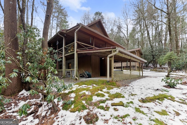 view of snow covered rear of property