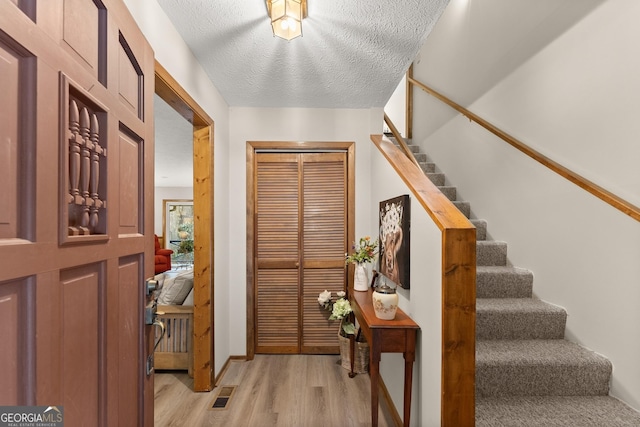 entrance foyer featuring light hardwood / wood-style floors and a textured ceiling