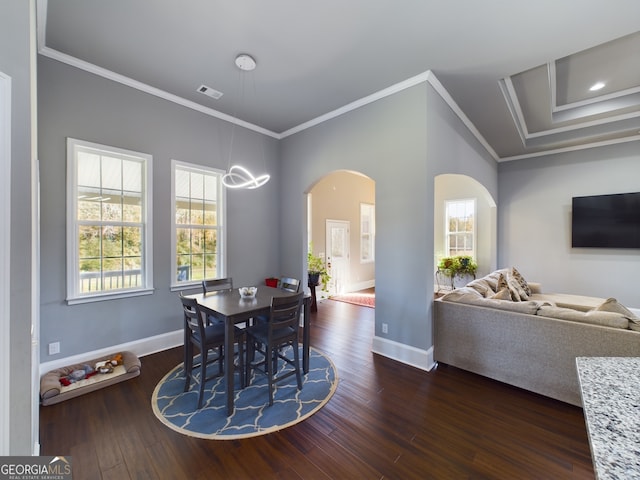 dining area with dark wood-type flooring, ornamental molding, and a wealth of natural light