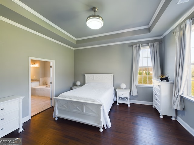 bedroom with crown molding, connected bathroom, a tray ceiling, and dark hardwood / wood-style floors