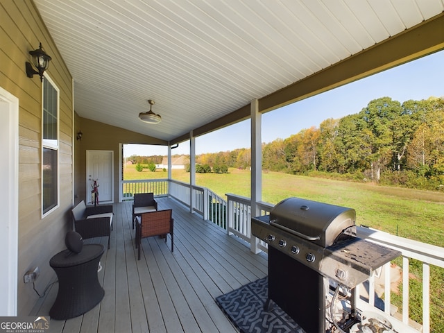 wooden deck featuring area for grilling, outdoor lounge area, and a lawn