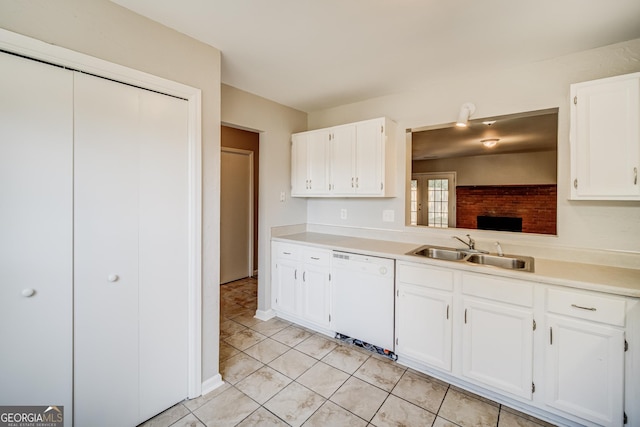 kitchen with white dishwasher, sink, white cabinetry, and light tile patterned floors