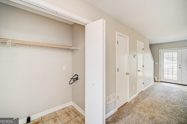 interior space featuring hookup for a washing machine and light colored carpet